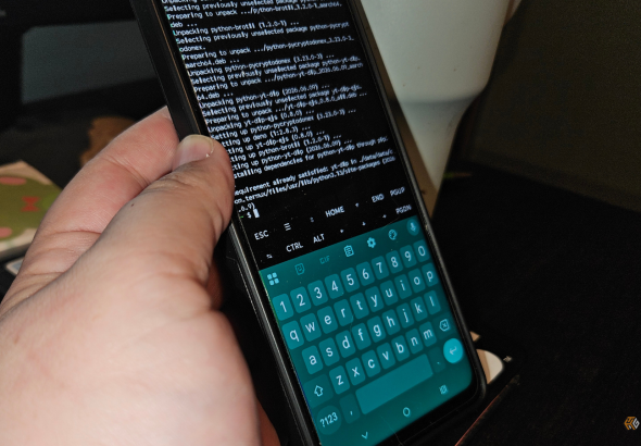 a-hand-holding-a-phone-showing-termux-downloading-and-installing-packages