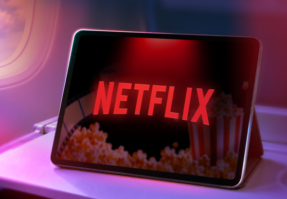 a-tablet-on-an-airplane-tray-table-showing-the-netflix-logo-with-haze